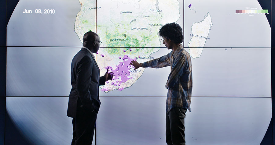 Two men looking at a digital map of Africa