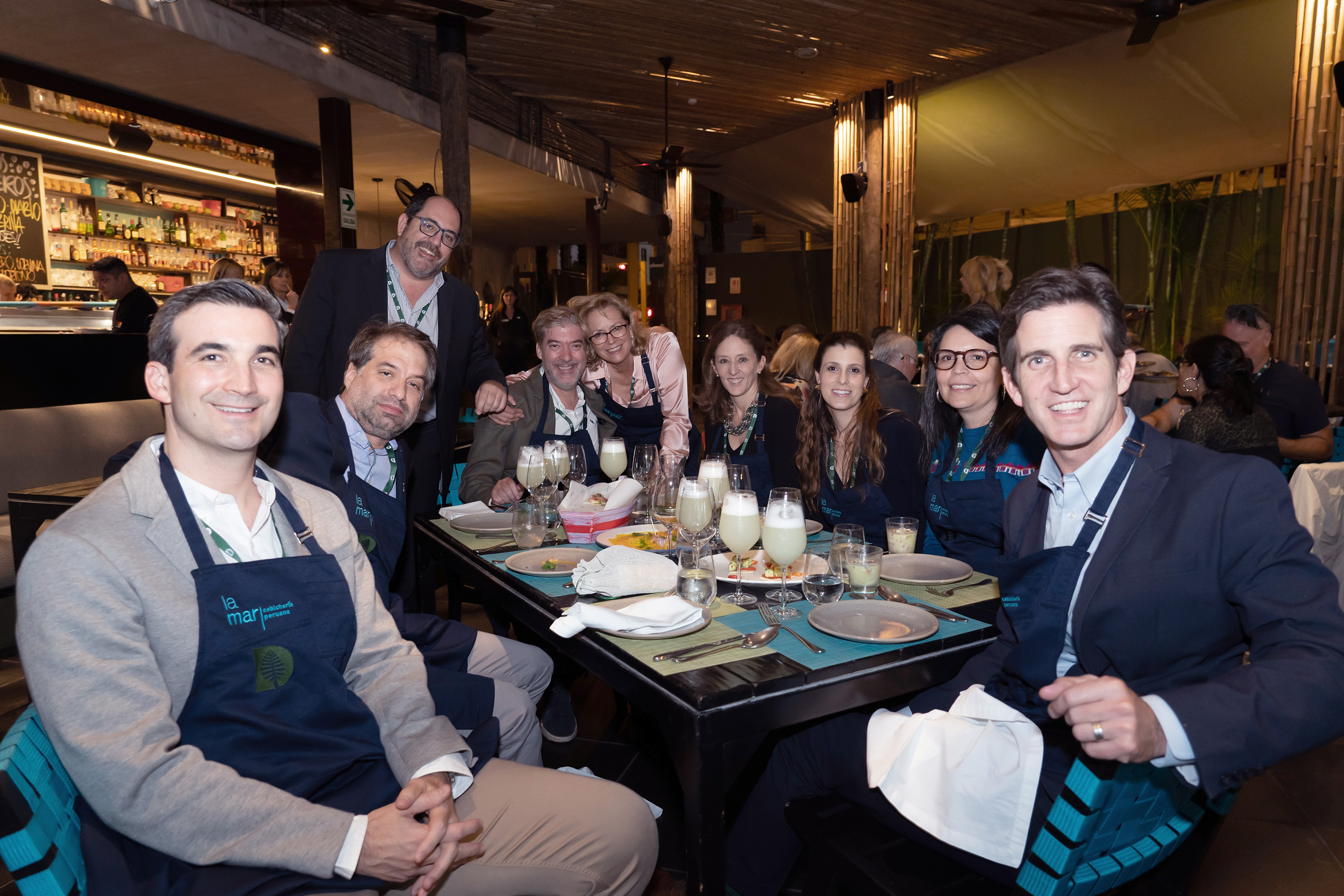 A group of alums sitting around a restaurant dinner table