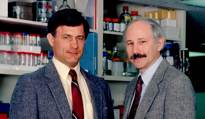 Two men inside with books in background