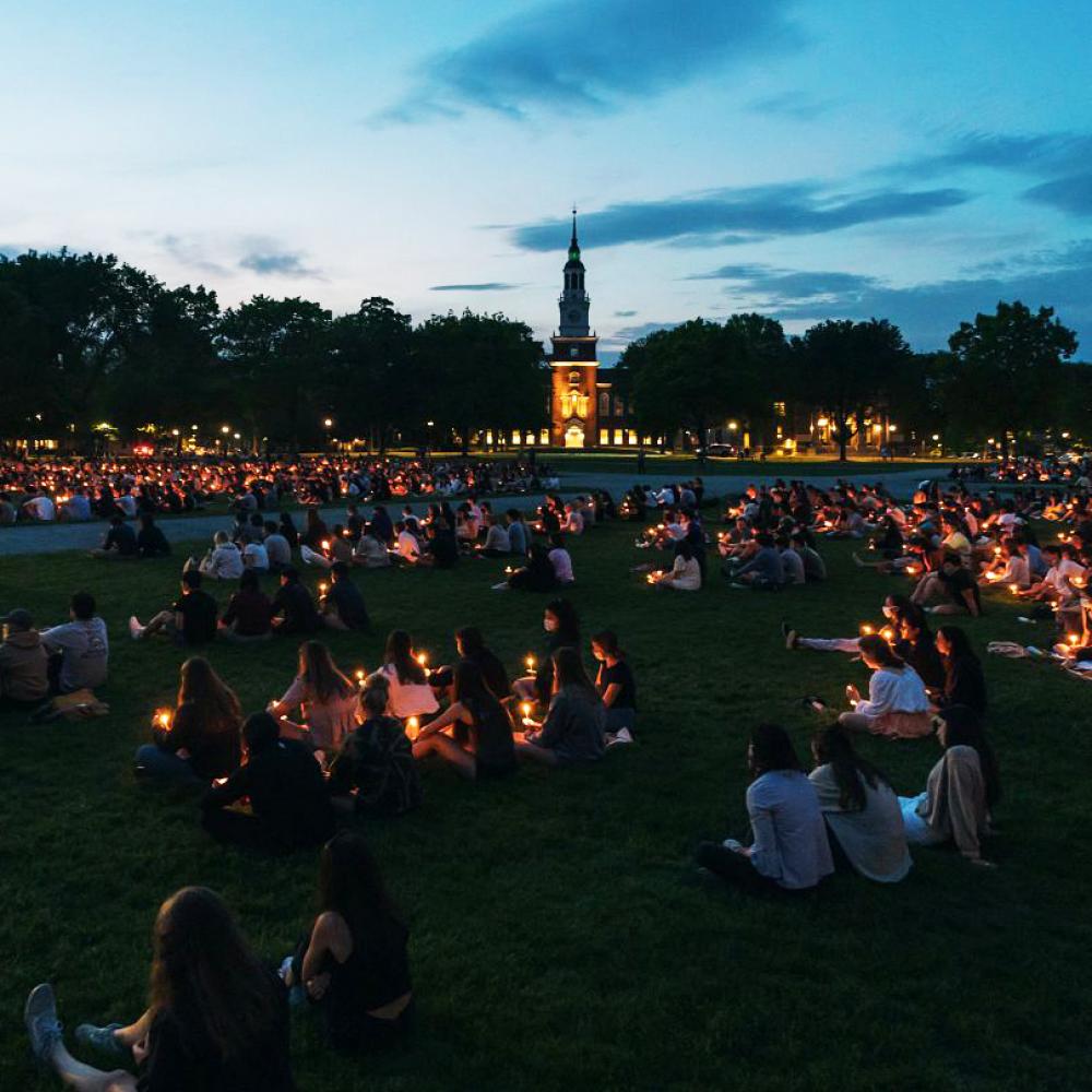 students on the green for a candlelight vigil