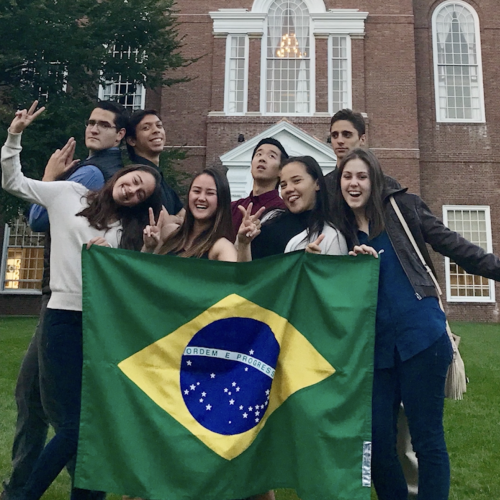 Students hold a Brazilian flag on the green