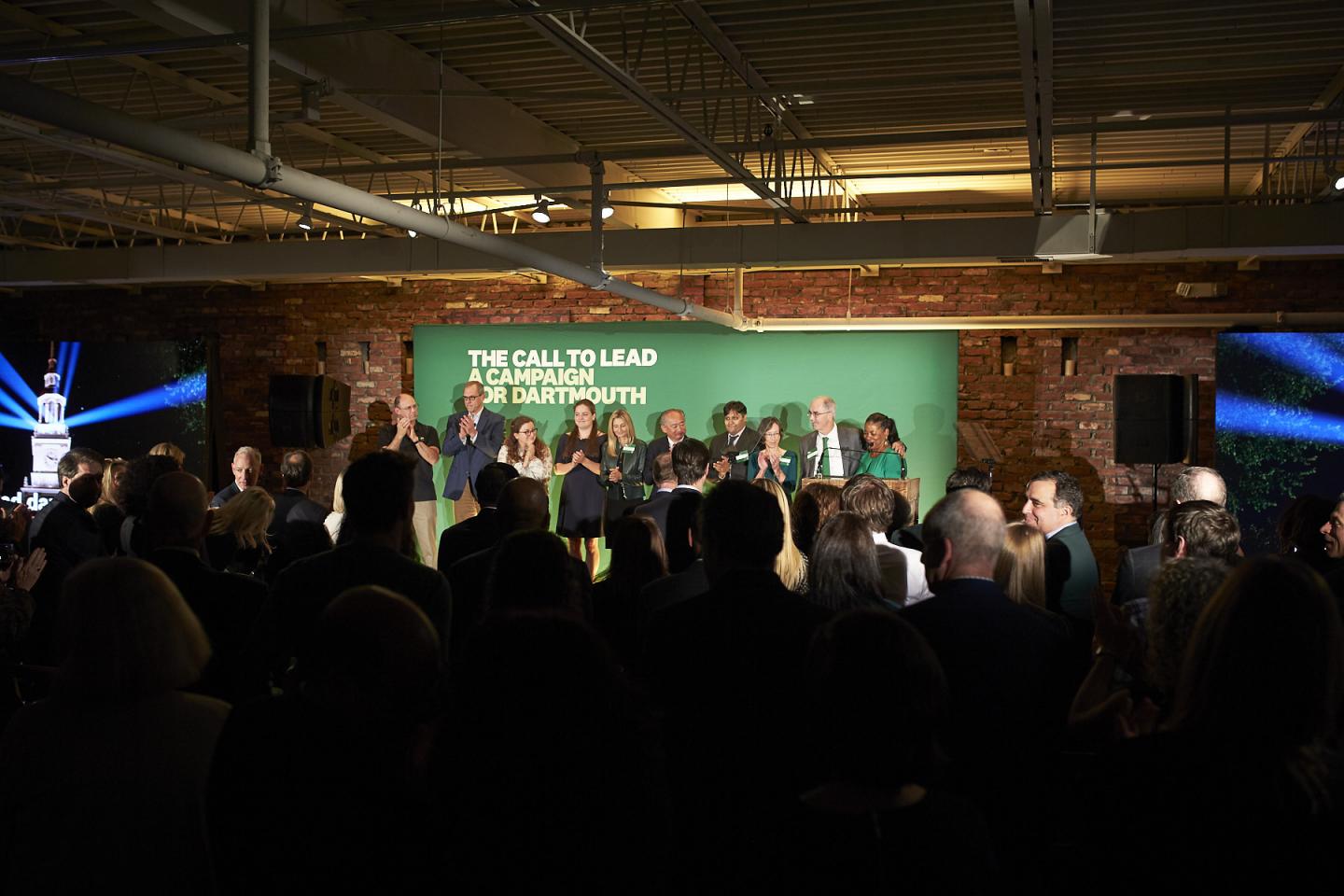 A crowd watches a group of people on a stage