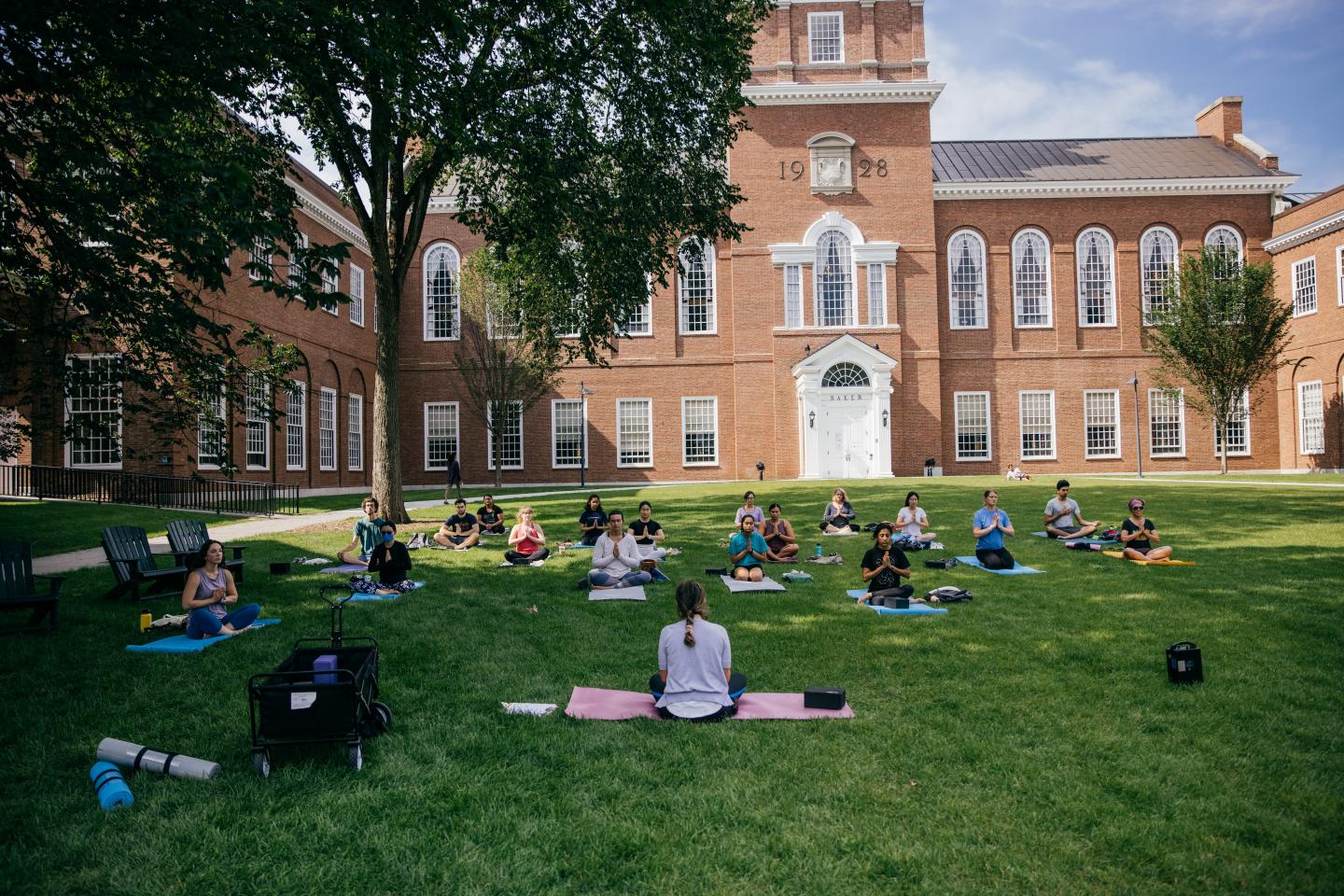Students meditating on the lawn in front of Baker library