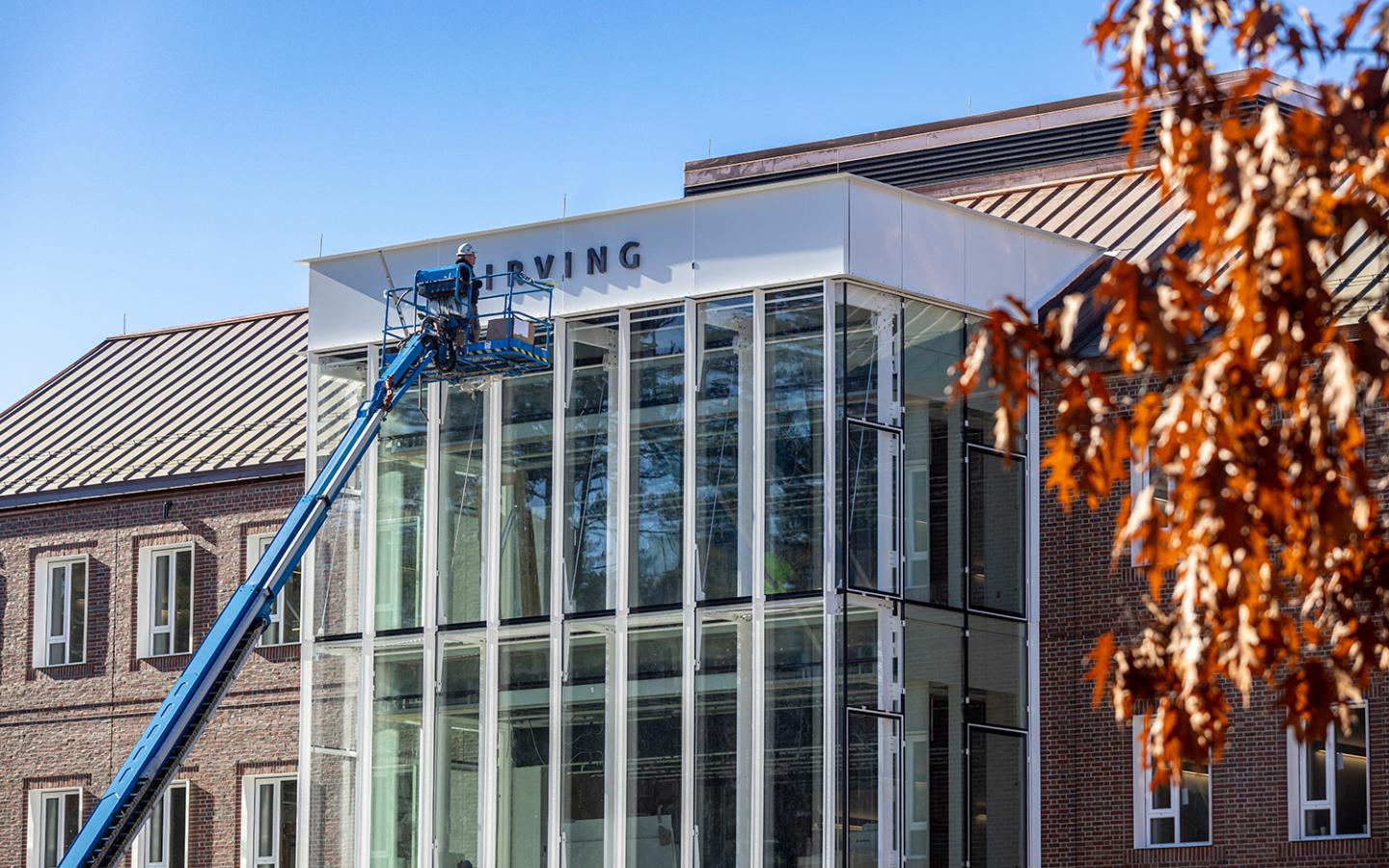Worker mounts the Irving name on the new home of the Irving Institute