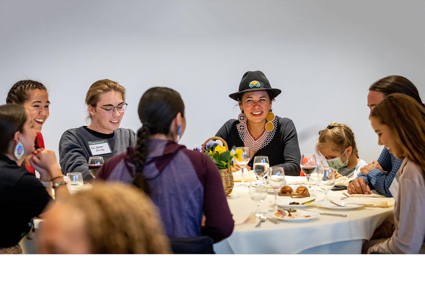 Students, alumni, and friends around a table at the Powwow honoring dinner