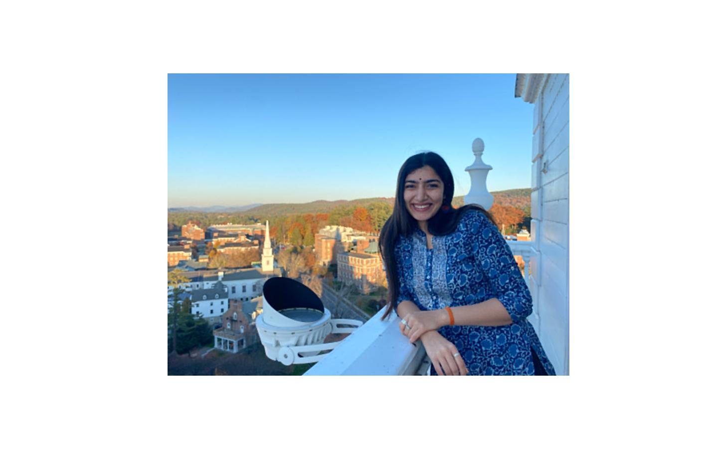 Nandini Prasad standing on a balcony overlooking a city