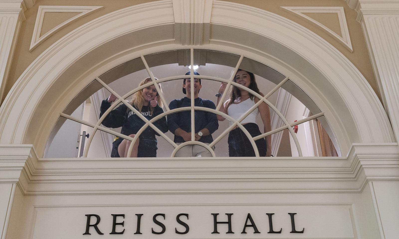 An interior window with "Reiss Hall" written in block letters.