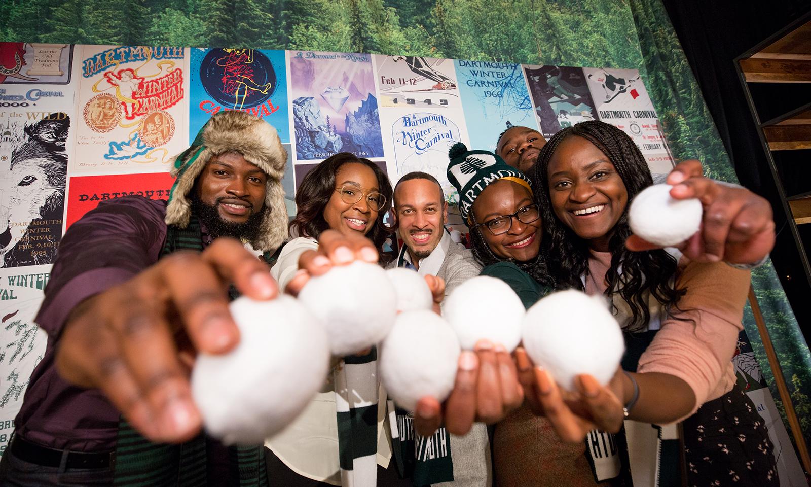 A group of happy people hold fake snowballs
