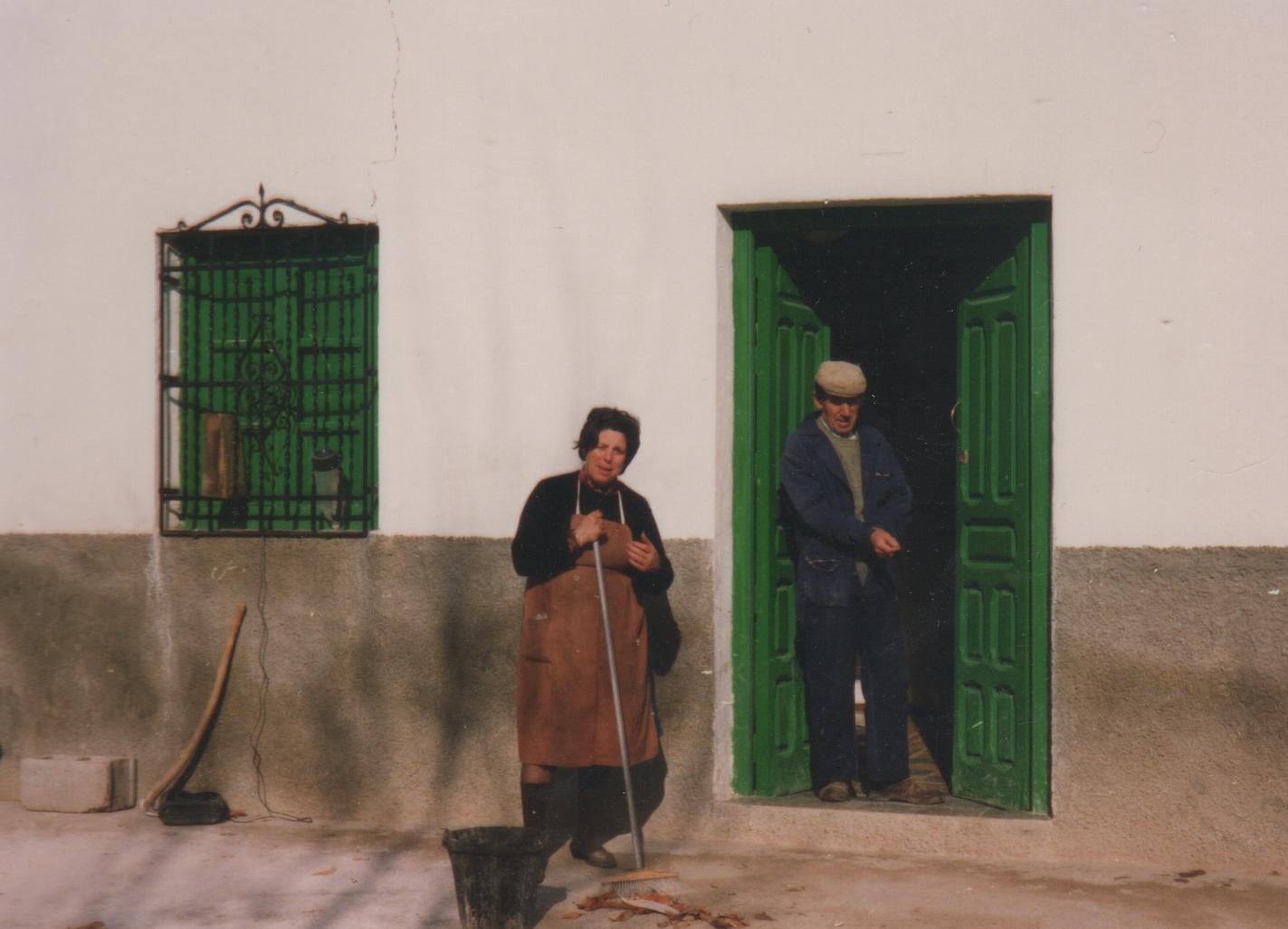A man and woman stand outside a home.