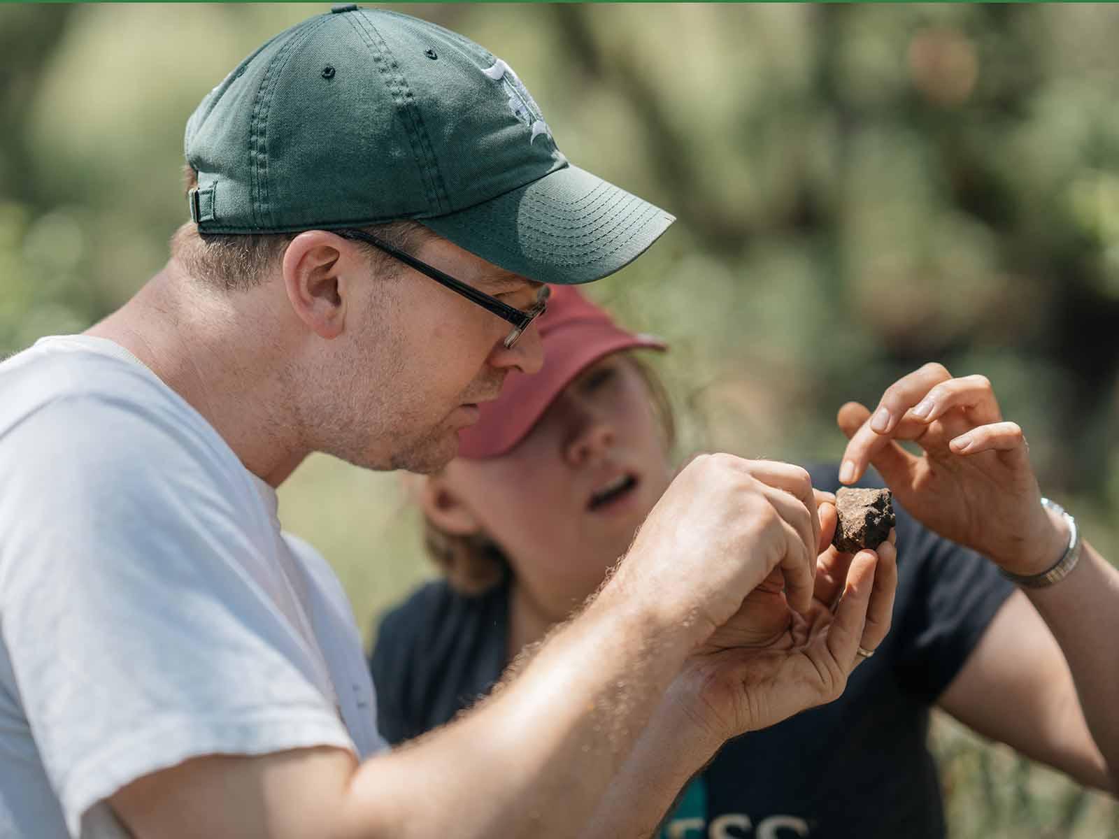 two people examining a rock