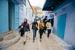 Four students walk down a colorful lane in Morocco.