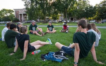 Students sit in a circle on the Green