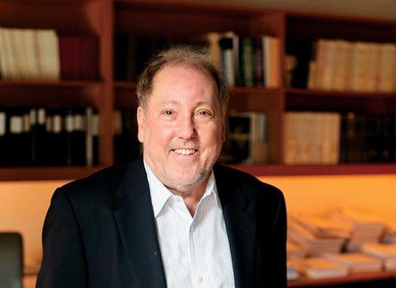 A smiling man in a room full of books